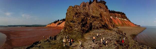 Fundy Basin at 5 Islands showing the Lower Jurassic McCoy Brook Formation to the left, the North Mountain Basalt (201- 202 ma) at center and the Late Triassic Blomidon Formation to the right. The tidal range along the coast is 15m (Photo C. Wong). 